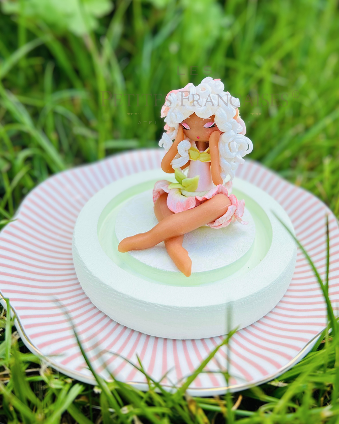 Azalée, poupée artisanale française de collection entièrement façonnée à la main en France en pâte polymère cernit. Création unique Les Petites Françaises, réalisée dans mon atelier près de Provins en Seine-et-marne. Figurine de collection issue de l'artisanat d'art français. Univers féérique inspiré des contes et légendes, avec des détails évoquant les maisons de poupées et le merveilleux et les créatures fantastiques.
