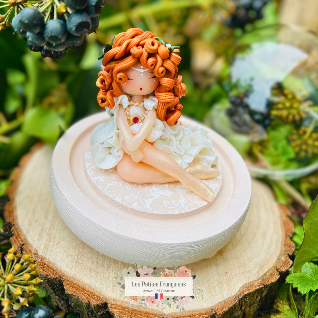 Mylène, poupée artisanale française de collection entièrement façonnée à la main en France en pâte polymère cernit. Création unique Les Petites Françaises, réalisée dans mon atelier près de Provins en Seine-et-marne. Figurine de collection issue de l'artisanat d'art français. Univers féérique inspiré des contes et légendes, avec des détails évoquant les maisons de poupées et le merveilleux et les créatures fantastiques.