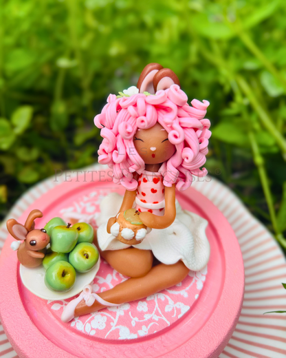 Pomme, poupée artisanale française de collection entièrement façonnée à la main en France en pâte polymère cernit. Création unique Les Petites Françaises, réalisée dans mon atelier près de Provins en Seine-et-marne. Figurine de collection issue de l'artisanat d'art français. Univers féérique inspiré des contes et légendes, avec des détails évoquant les maisons de poupées et le merveilleux et les créatures fantastiques.